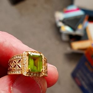 14k gold encrusted with diamonds and a large emerald.